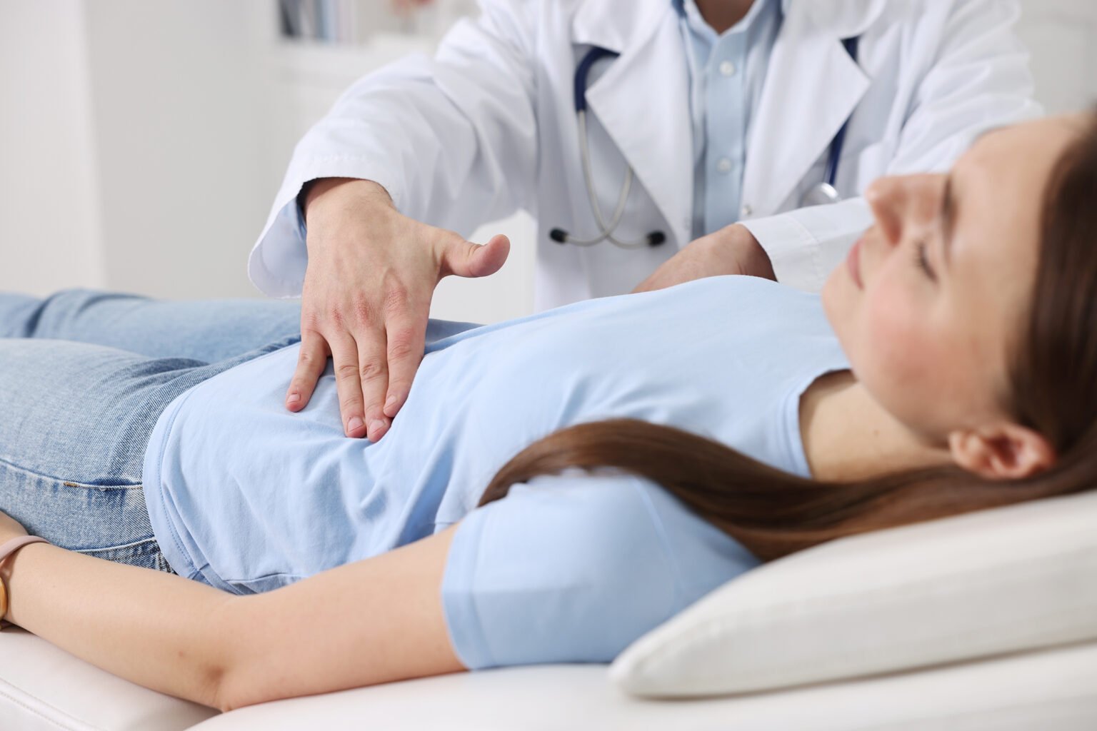 Gastroenterologe untersucht einen Patienten mit Magenschmerzen auf der Liege in der Klinik, Nahaufnahme